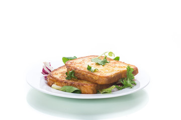 fried croutons in eggs with greens in a plate