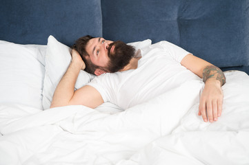 Man bearded hipster having problems with sleep. Guy lying in bed try to relax and fall asleep. Relaxation techniques. Violations of sleep and wakefulness. Sleepless night. Sleep disorders concept