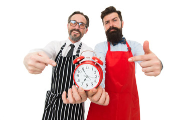 Time to cook. Men pointing at alarm clock. Man bearded hipster and mature chef apron white...