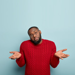 Why not to choose this? Clueless bearded unshaven Afro American guy shruggs shoulders, being...