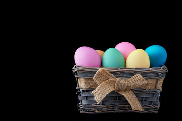 Happy easter, dyed colored eggs in the basket on the one-color background.