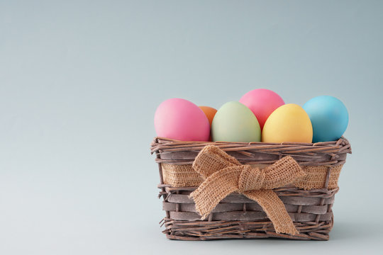 Happy easter, dyed colored eggs in the basket on the one-color background.