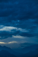 Beautiful sunset sky over peaks of mountains. Vertical color photography.