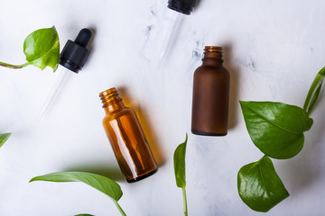 Glass bottles for natural cosmetics on a white marble background