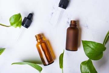 Glass bottles for natural cosmetics on a white marble background