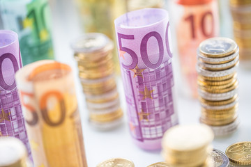 Rolled euro banknotes and coins towers stacked in other positions