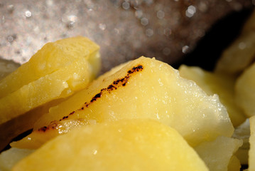 Fried potatoes in a pan looks delicious. Shallow depth of field
