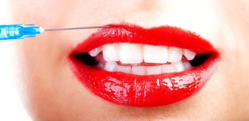 Naklejka premium Beautiful young woman receiving filler injection in lips, closeup