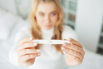Pregnancy test. Worried sad woman Looking at a Pregnancy Test after result