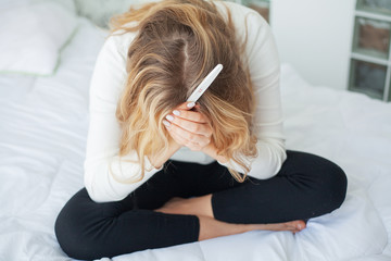 Pregnancy test. Worried sad woman Looking at a Pregnancy Test after result