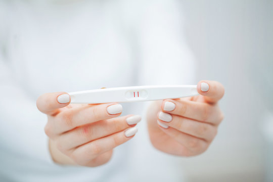 Woman Holding Pregnancy Test with positive results