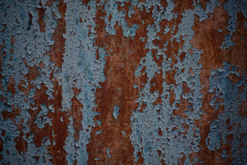 Rusty iron door with cracked blue paint. Painted blue rusty wall shaped texture. Grunge rusty corrosive background painted blue. Steel plate background. Construction industry. Rusty metal background.