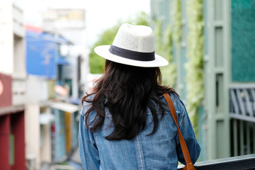 Back side of  woman traveler standing with city outdoors background, casual lifesyle, travel blogger