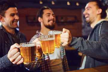 Friends with glasses of beer in hand at the bar.