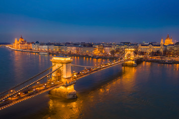 Fototapeta na wymiar Budapest, Hungary - Aerial view of the famous illuminated Szechenyi Chain Bridge at blue hour with Parliament building and St.Stephen's Basilica at the background