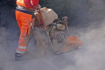 Bauarbeiter sägt den Asphalt auf