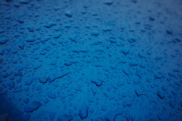 clean water drops on the blue car on the street