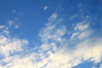 Beautiful bright delicate white clouds on a background of blue summer sky