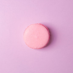 Pink macaroon on pink background closeup top view. Copy space. Minimal food.