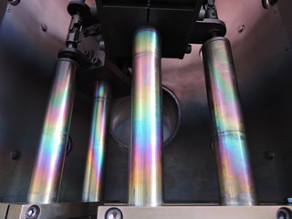 Rainbow on coated steel rods inside vacuum deposition chamber