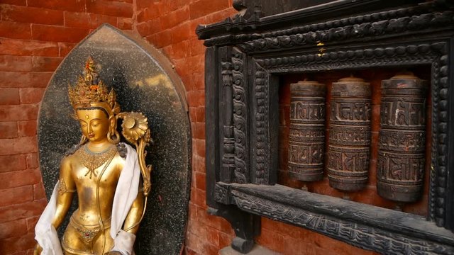 Row of aged religious prayer wheels or drums with mantra Om Mani Padme Hum in yard of temple, Durbar Square, Nepal, Kathmandu. Tibetian buddhism