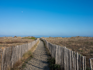 Sandy beach path with wooden railings. Pathway to beach and ocean sea. Minimal artistic nature landscape photography.