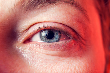 Close-up blue eye of a woman with a tear. People and emotions concept