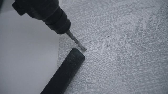 A Builder drills a hole in the wall