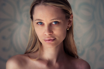 Fototapeta premium beautiful woman with long blonde hair in knitted sweater posing on light backgrounde in studio