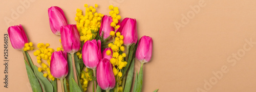 Spring Summer beige background with spring flowers. Free space. Copy space.Top view. Tulips and mimosa.