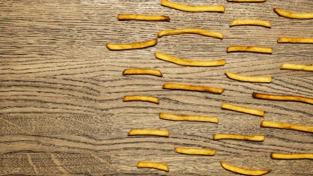French fries potatoes time laps. Wood background.