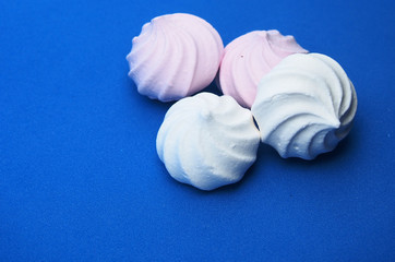 Meringue cookies pink and white on a blue background.