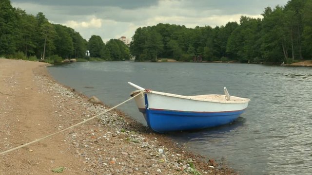 Moored Rowing boat with oars on the river bank