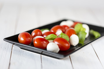 Dish with fresh caprese salad isolated on white
