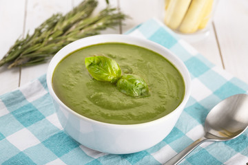 Green cream soup of spinach and chickpeas on concrete wood background