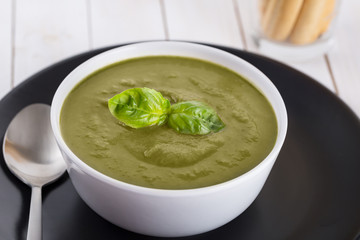Green cream soup of spinach and chickpeas on concrete wood background