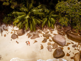 Aerial drone view of couple on the tropical beach of the Seychelles island