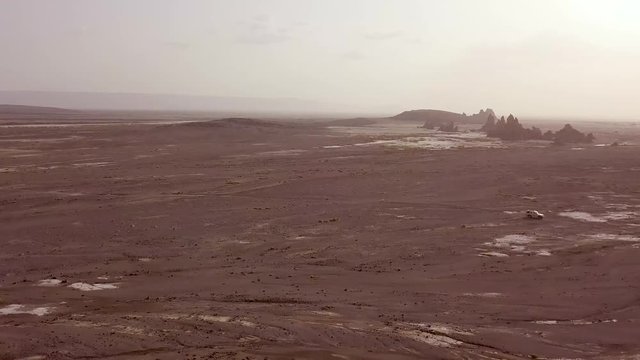 Good aerial over two 4 WD jeeps driving across a wild and rugged landscape in Djibouti or Somalia.