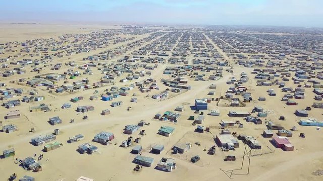 Aerial over a strange abandoned town of empty lonely suburban tract houses in the desert of Namibia, Africa.