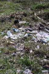 Environmental pollution. Rubbish in the green grass on nature. Ruined landscape. Stock background, photo