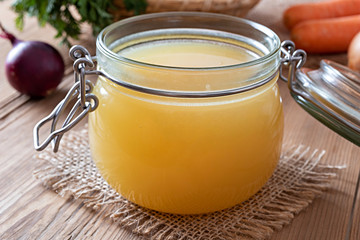 Chicken bone broth in a glass jar with vegetables