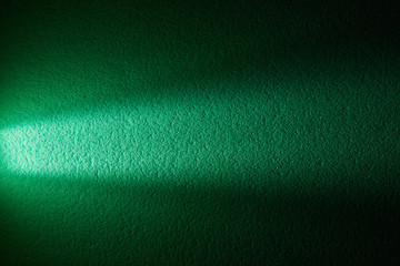 Ray of light on textural dark green background