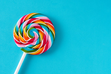 Colorful lollipop on blue background. Top view. Copyspace