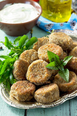 Middle eastern or arabic dishes. Fresh vegetarian falafel. Mung falafel with garlic yogurt sauce on wooden table.