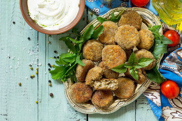 Middle eastern or arabic dishes. Fresh vegetarian falafel. Mung falafel with garlic yogurt sauce on wooden table. Top view flat lay background with copy space.