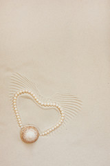 Fototapeta na wymiar Pearl necklace on white fine sand with sea shell. Luxury resort, ocean or sea wedding concept