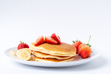 Homemade Pancakes with fresh strawberries and slice banana and honey on white plate,Healthy breakfast.