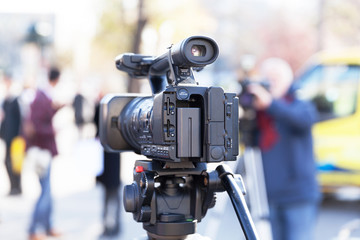 Television camera in the focus, blurred people in the background