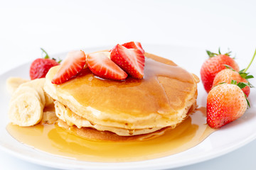 Homemade Pancakes with fresh strawberries and slice banana and honey on white plate,Healthy breakfast.