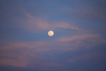 Full moon on sunset sky
